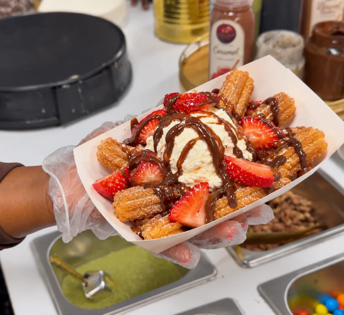 Cinnamon sugar churros served with vanilla ice cream, fresh strawberries and chocolate drizzle
