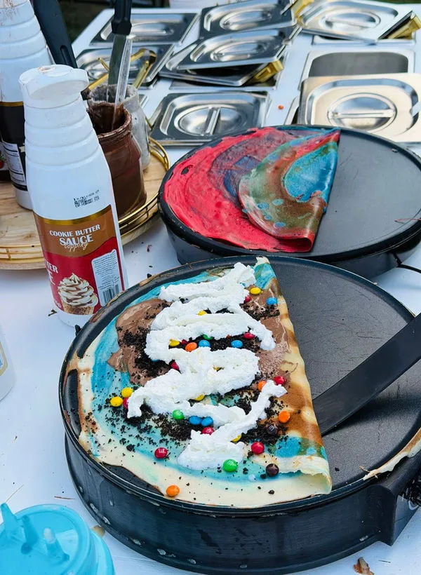 Playful dessert crepe finished with candy and whipped cream